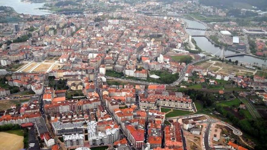 Vista de la ciudad con tres solares sin edificar: A Eiriña (dcha.), Tafisa (izda.) y Valdecorvos (abajo).  // R. V.