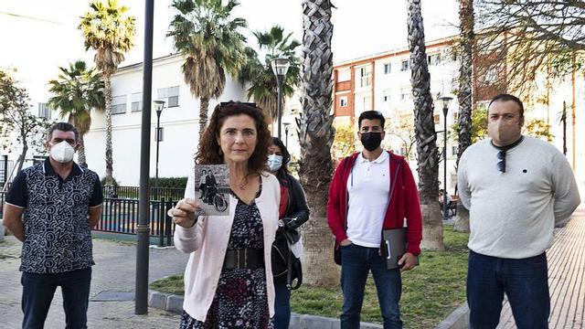 Silvia Morán, hija del practicante, sostiene una foto de sus padres en la plaza junto a la calle Mar donde se encontraba su consulta, y en la que la Asociación Cultural El Palo promueve que vaya el busto.