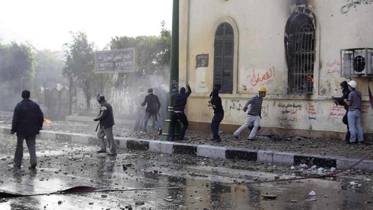 Los manifestantes lanzan piedras contra los soldados cerca de la plaza Tahrir.