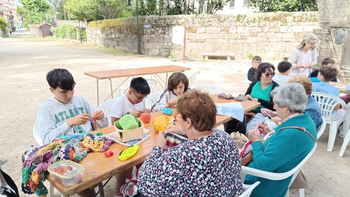 Unas vecinas de Cambados enseñan a unos alumnos del Cabanillas a ganchillar.