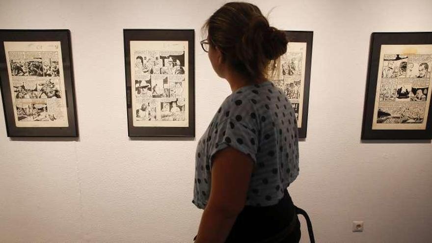 Una mujer observa algunas de las viñetas de la exposición sobre el cómic que exhibe la Casa de Cultura de Avilés.