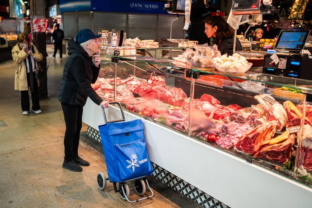Barcelona, 17/12/2025. Sociedad. Clientela local compra en paradas del Mercat de la Boqueria, un retrato de los vecinos que todavía mantienen el mercado como espacio de compra cotidiana, mostrando quiénes son y qué productos adquieren. Foto: Zowy Voeten / El Periódico