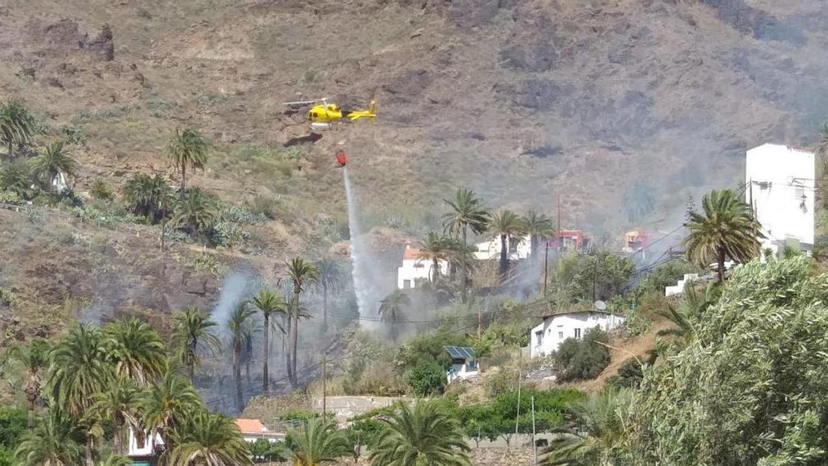 Un helicóptero actúa en un incendio en el pueblo de Fataga, en el municipio de San Bartolomé de Tirajana.