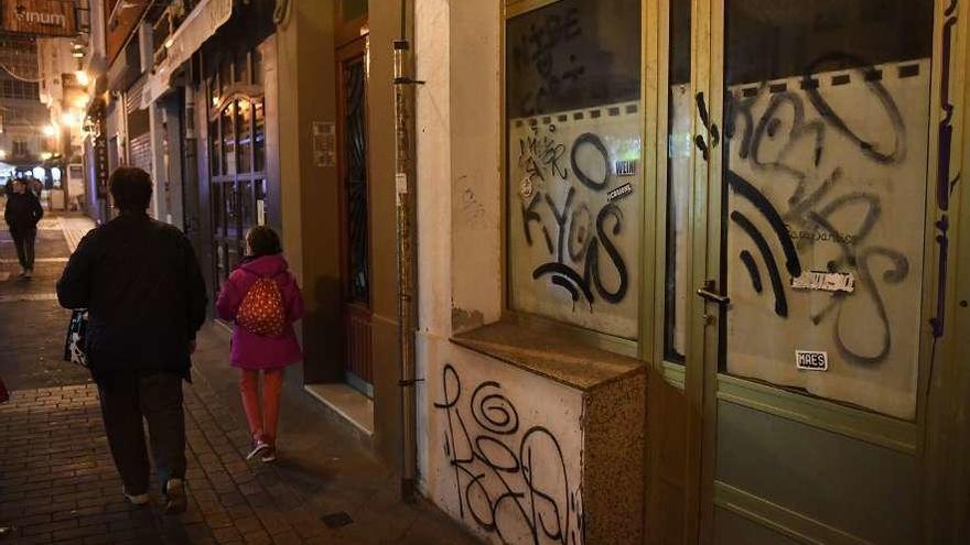 Establecimiento comercial cerrado con el escaparate pintado en una calle céntrica.