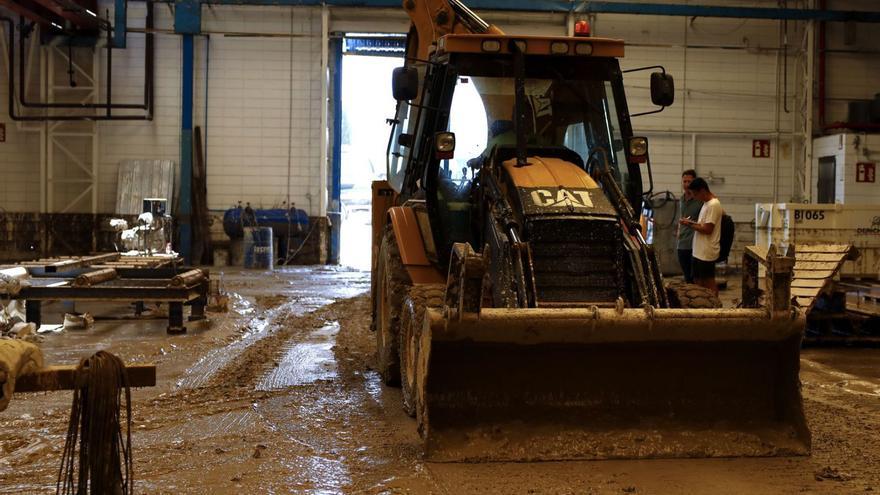 Una excavadora trabaja retirando el barro en Desplek Construction para reanudar la producción con la mayor celeridad posible. | MIGUEL ÁNGEL GRACIA