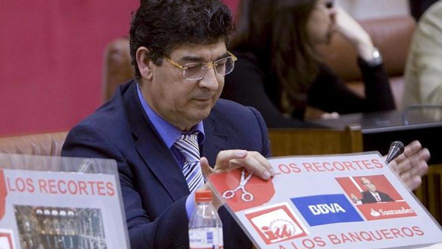 El coordinador de IULV-CA , Diego Valderas, que asume como el resto de diputados una rebaja salarial del 15%, muestra uno de los carteles reivindicativos para que este recorte se haga extensivo a los altos cargos, a directores de las cajas de ahorro, de bancos, responsables de las empresas públicas y otras instituciones, durante el pleno del Parlamento Andaluz en Sevilla.