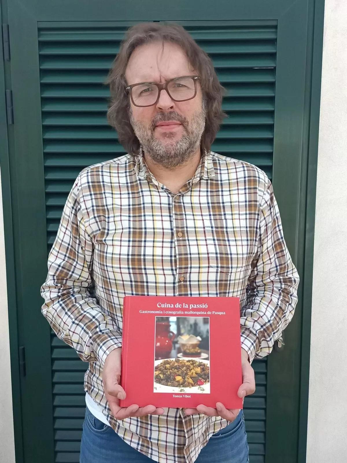 Der Historiker Tomàs Vibot mit seinem Buch zur Osterküche auf Mallorca.