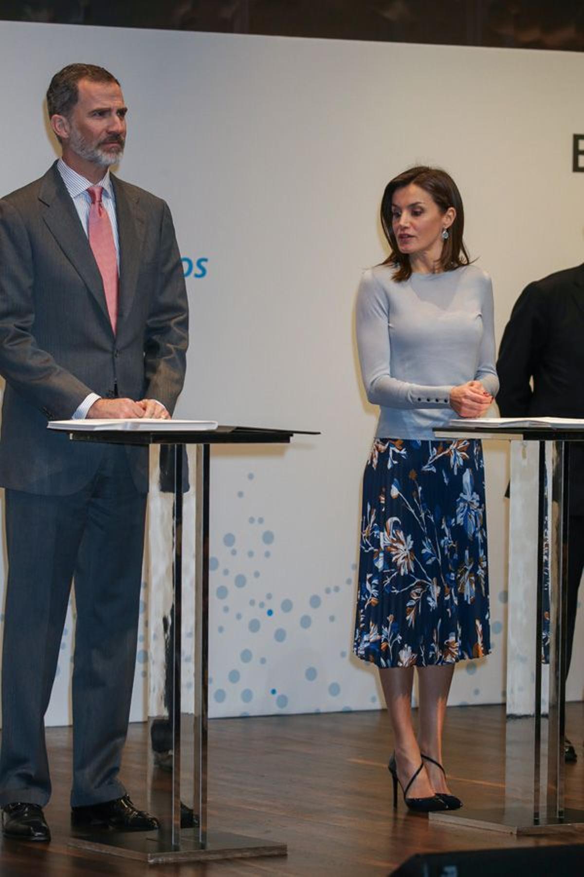 Letizia Ortiz con falda de flores de Hugo Boss y jersey de punto gris junto a Felipe VI