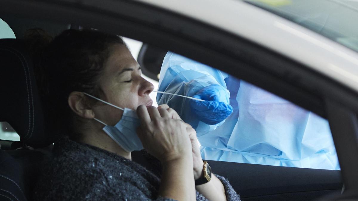 Una sanitaria le realiza la prueba PCR a una mujer en su coche.