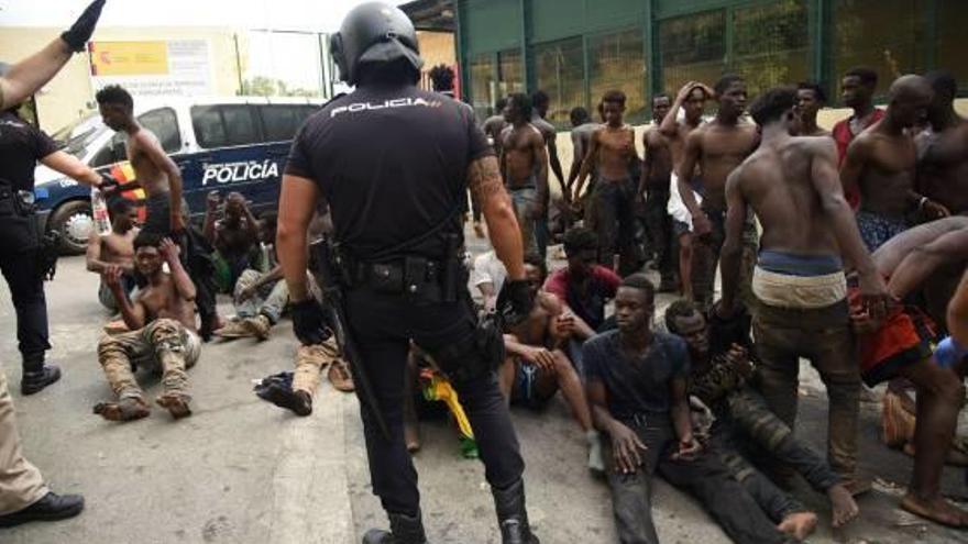 Un policia custodia els immigrants arribats.