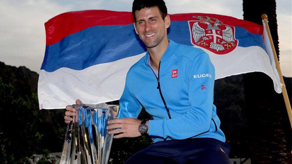 Djokovic posa con el trofeo y la bandera de Serbia