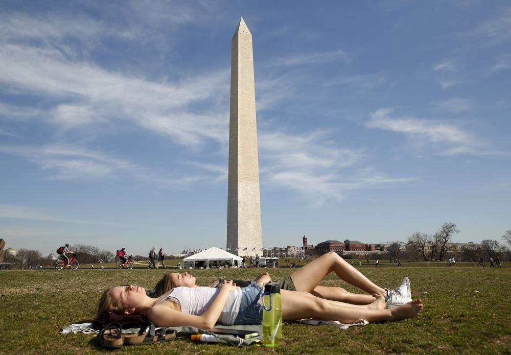 Students sunbathe on a unseasonably warm day in ...