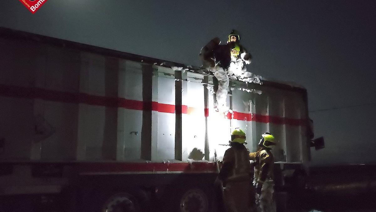 Los bomberos arrojando espuma en la bañera del camión.