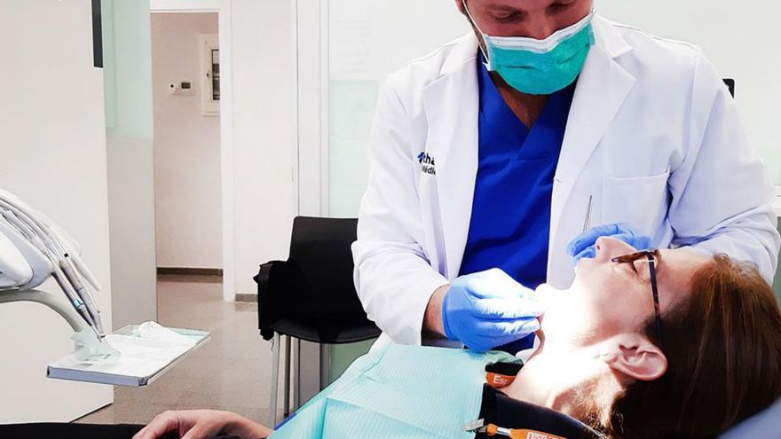 Un dentista examina a una paciente.