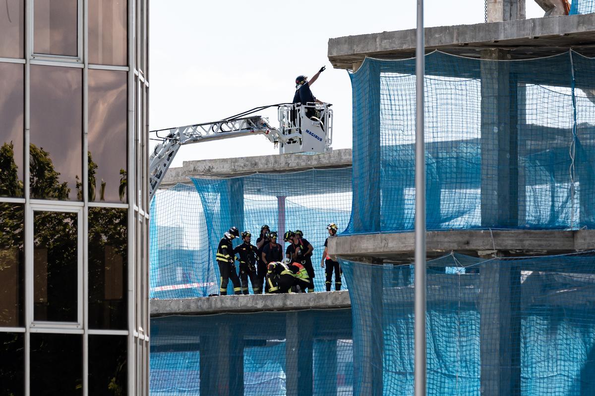 Los bomberos rescatan los cuerpos sin vida de los dos trabajadores sepultados en un edificio en Madrid
