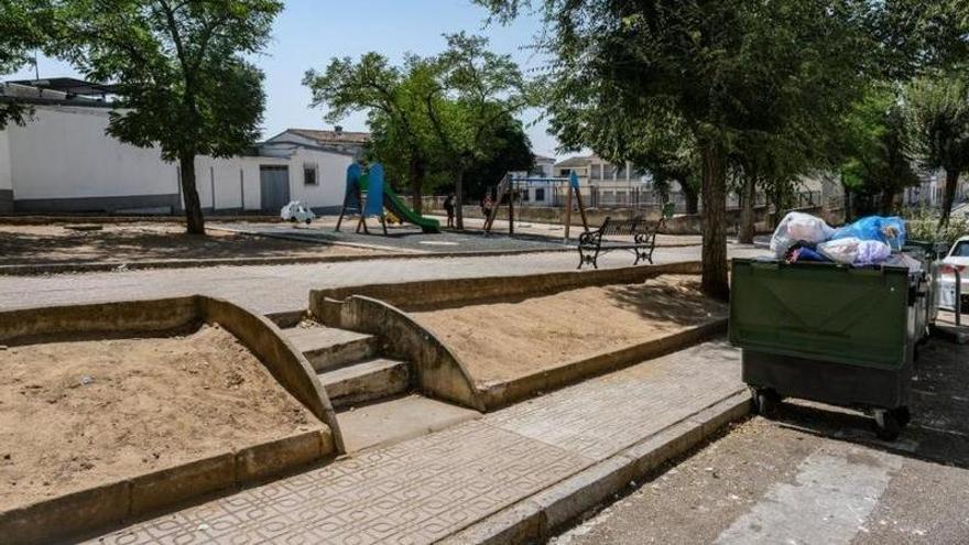 Escaleras que dan acceso al parque, rodeado de contenedores llenos de basura.