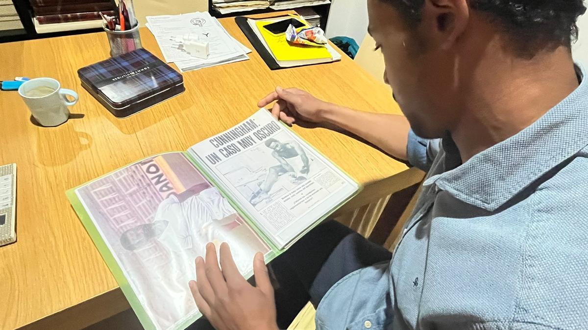 Sergio Cunningham, en su casa, viendo uno de los múltiples álbumes de recuerdos de su padre.