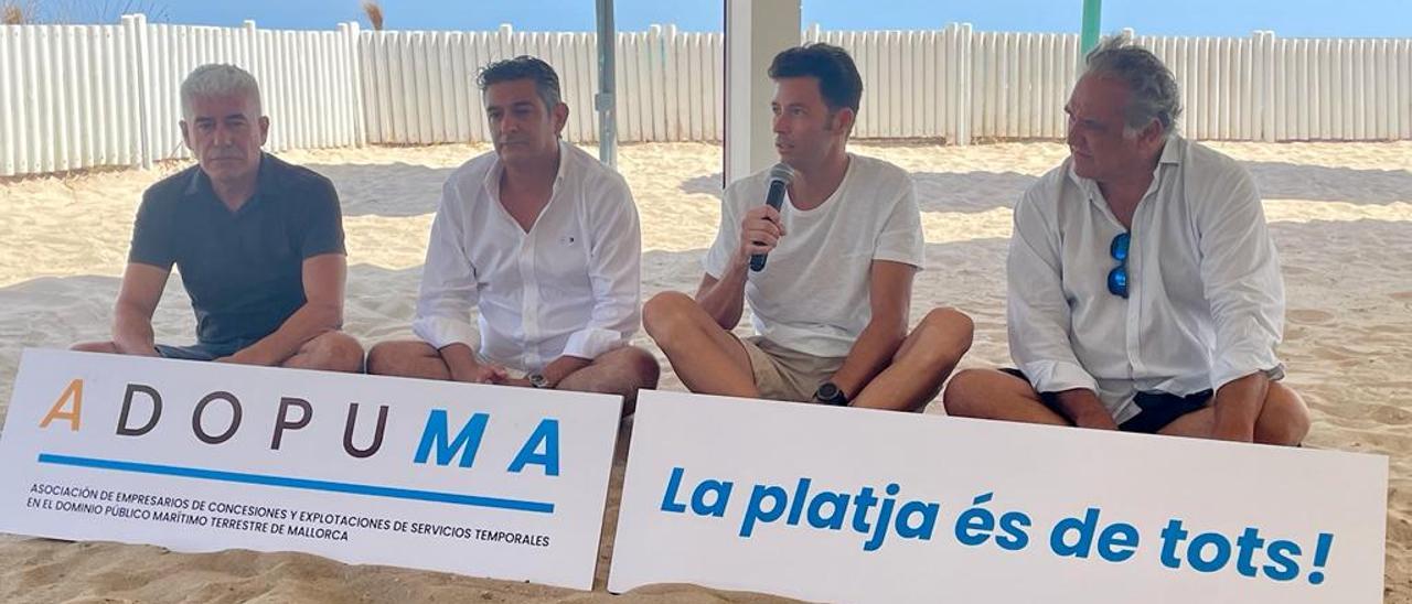 Promotores de la asociación, en Can Gavella, sentados sobre la arena en la zona donde antes se autorizaba una terraza.