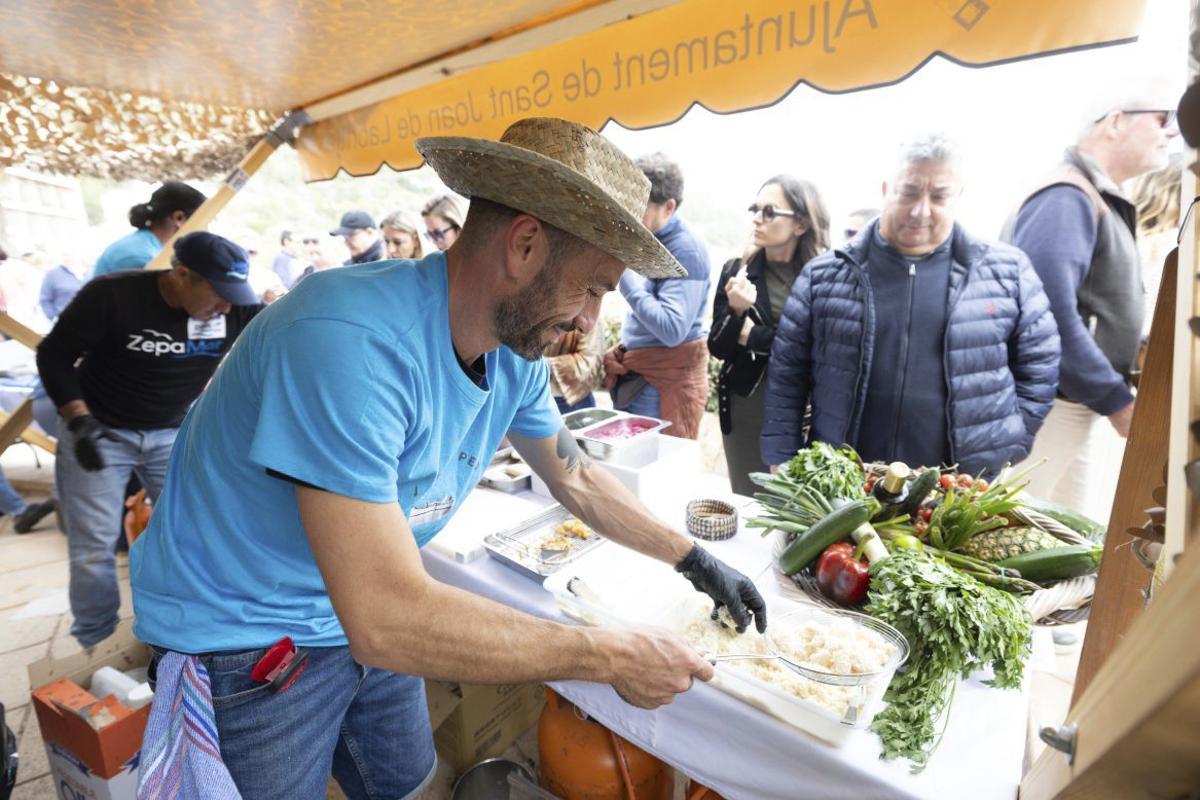 Uno de los participantes en la feria gastronómica del pescado cocina frente a los visitantes.