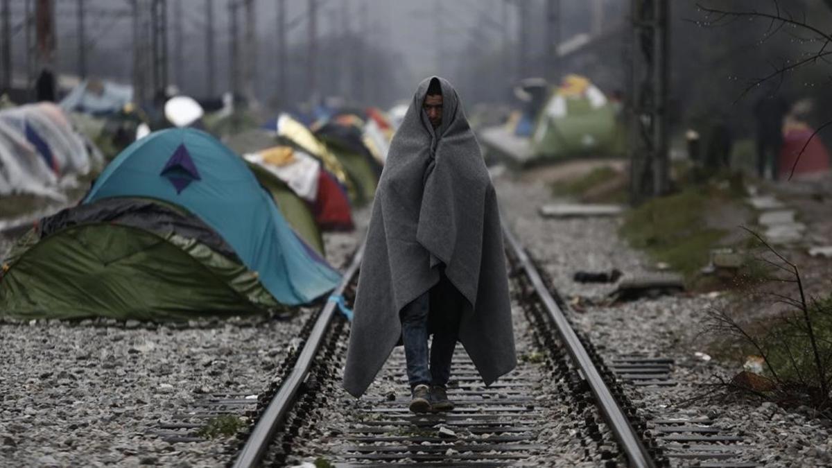Un refugiado envuelto en una manta, en un campo de refugiados en la frontera entre Grecia y Macedonia, cerca de Idomeni (Grecia), este jueves.