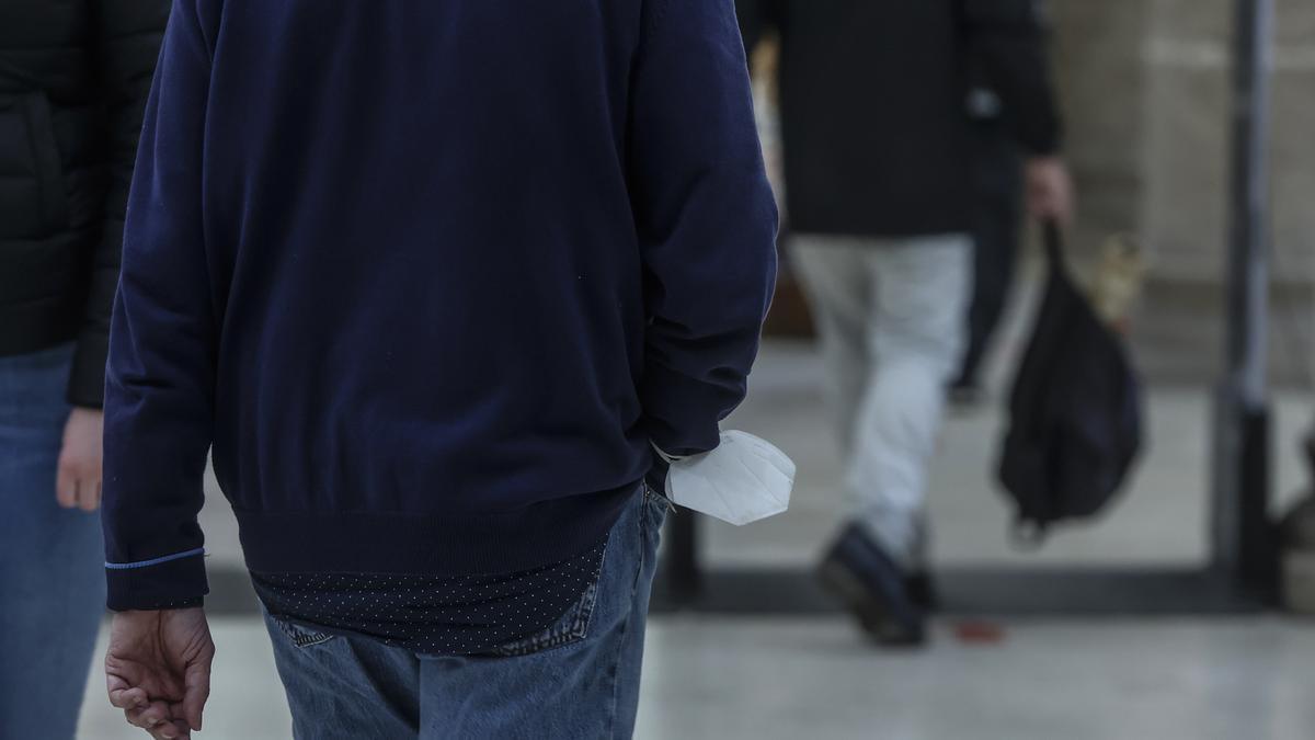 Un hombre con su mascarilla en la muñeca, en el Mercado Central.