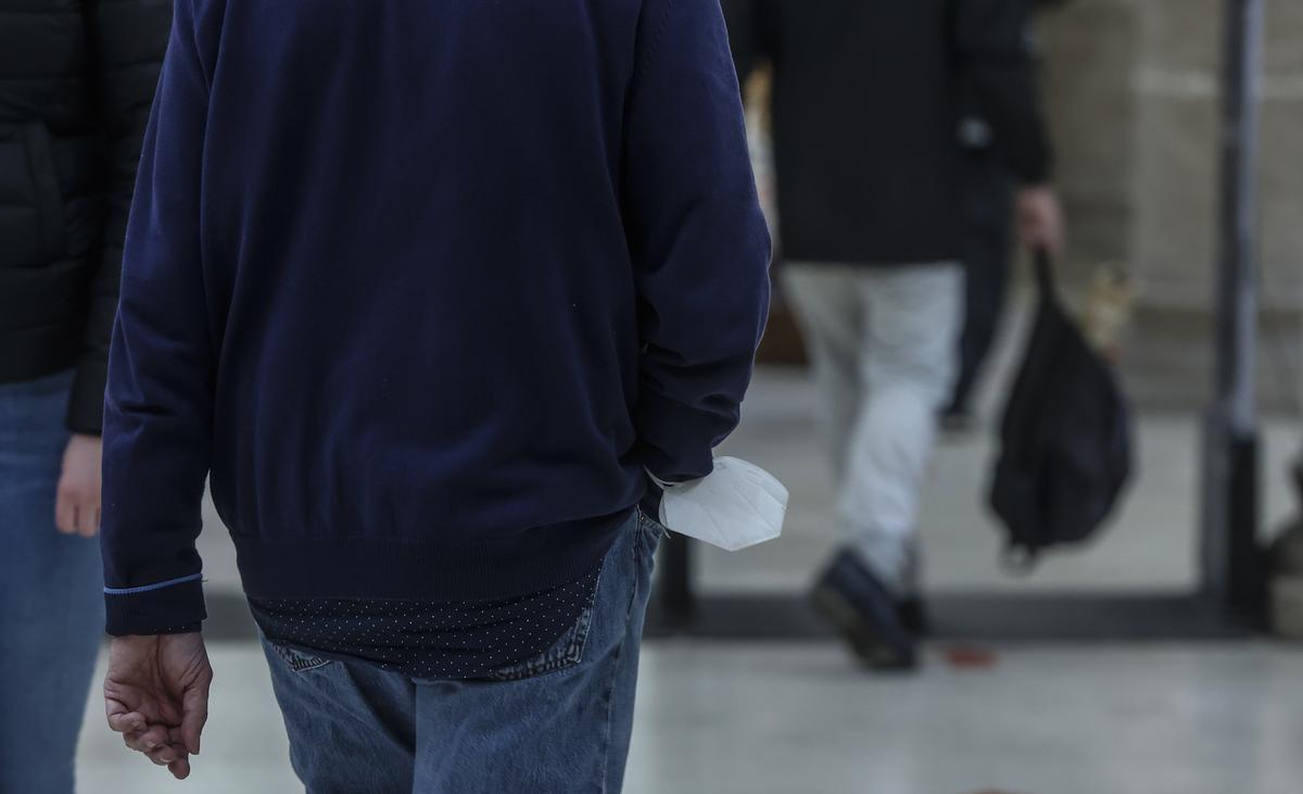 Un hombre con su mascarilla en la muñeca, en el Mercado Central.