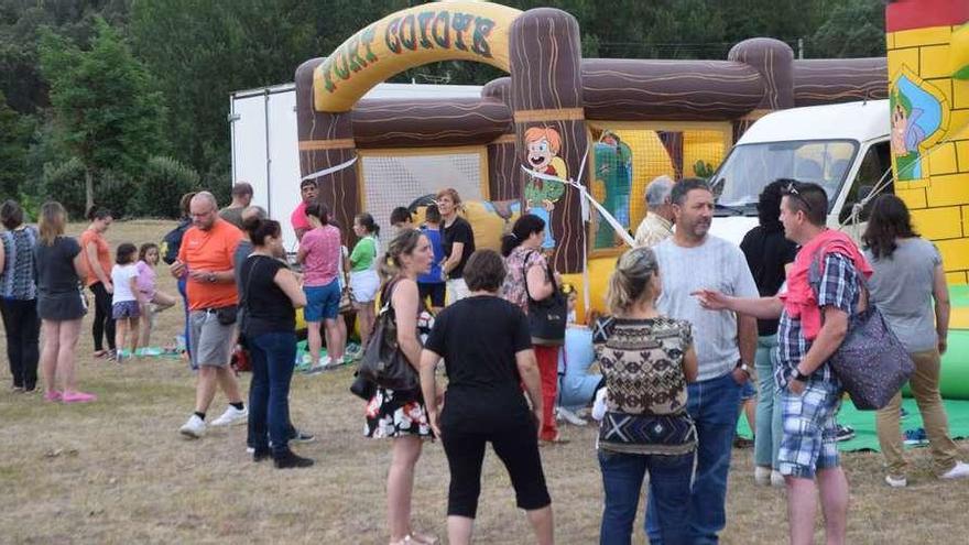 Niños y mayores se divierten en el parque hinchable.