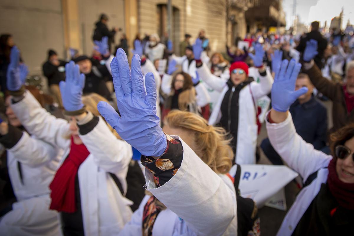 Varias personas con batas blancas y guantes azules protestan durante una marcha convocada por médicos y pediatras de Atención Primaria, a 1 de febrero de 2023, en Madrid (España). Como cada miércoles, los médicos y pediatras de Atención Primaria de Madrid vuelven a protestar en la octava semana de huelga bajo el lema, 'Por una atención Primaria de calidad. Es el momento, ahora o nunca'. La protesta coincide con el día en el que se reúne la Consejería de Sanidad y el Comité de Huelga de médicos y pediatras de Atención Primaria para llegar a un acuerdo que ponga fin a los paros que arrancaron el pasado día 21 de noviembre. 01 FEBRERO 2023;HUELGA;CONCENTRACIÓN;PROTESTA;MANIFESTACIÓN;MEDICINA;SALUD PÚBLICA;RECORTES;SERVICIO PÚBLICO; Juan Barbosa / Europa Press 01/02/2023. Juan Barbosa