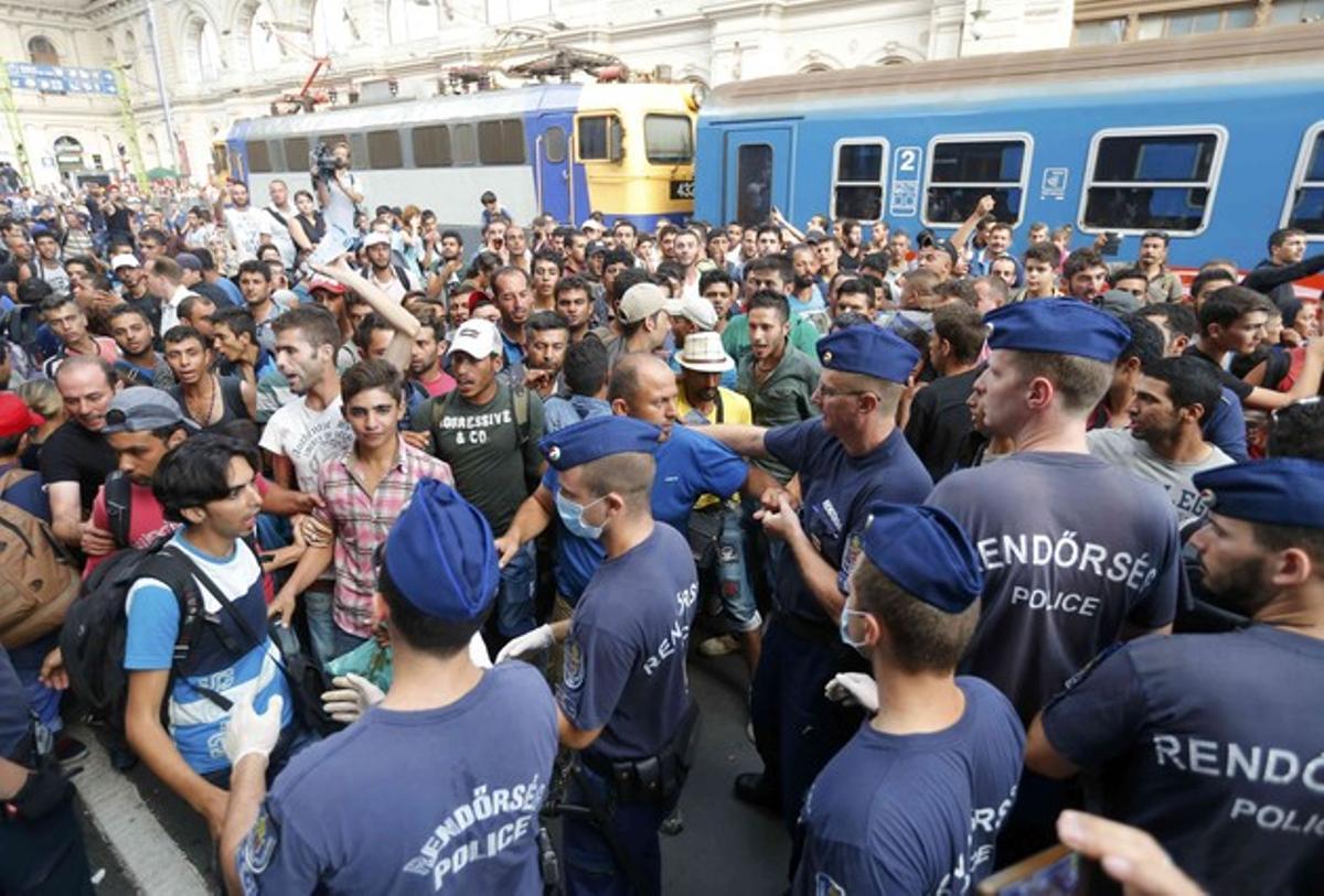Miles de inmigrantes se enfrentan a la policía húngara en la estación de trenes de Keleti que los agentes la hayan cerrado tras intentar desalojarles para impedir que los refugiados puedan llegar a otros países europeos.