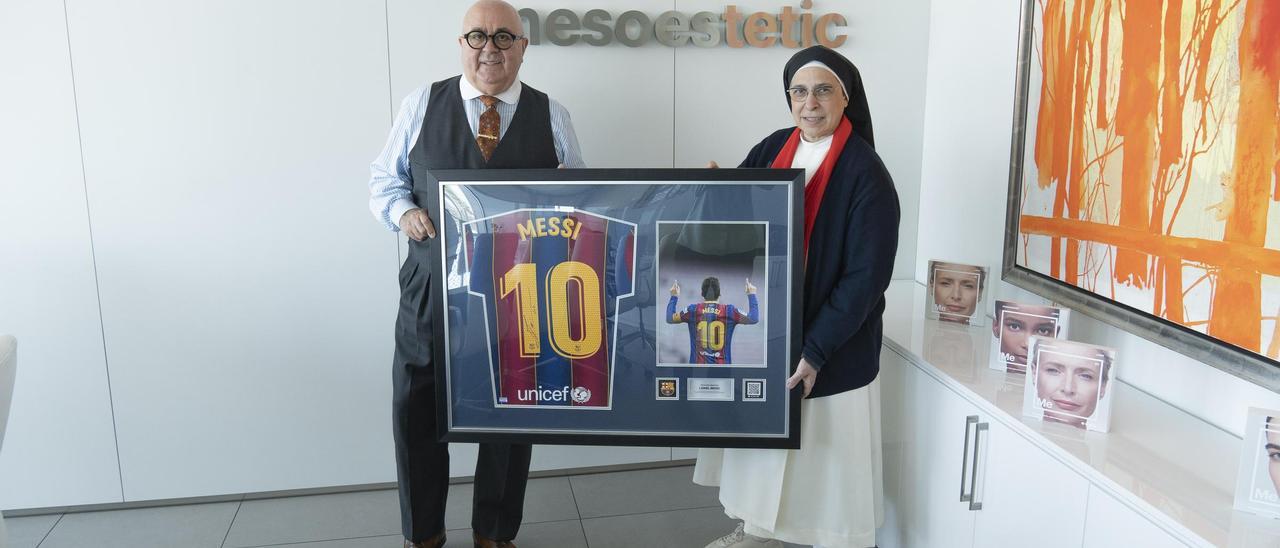 Sor Lucía lliura a Joan Carles Font, fundador i director executiu de l'empresa Mesoestetic, de la semarreta de Messi emmarcada