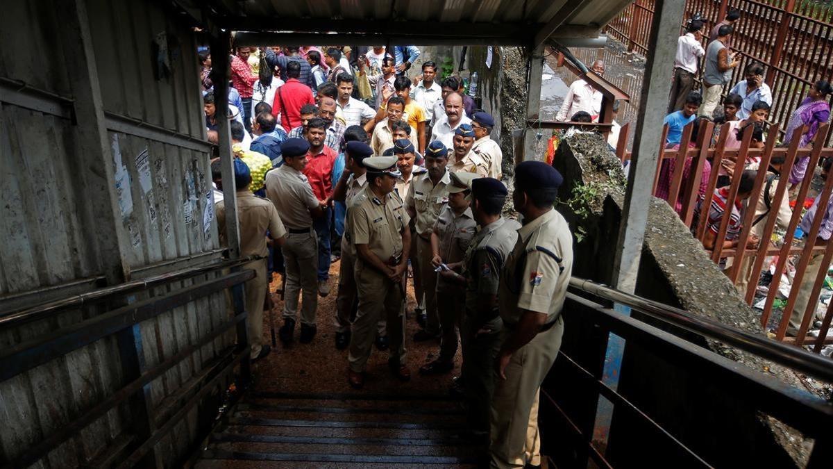 Policías inspeccionan el lugar de la estampida en un puente de peatones sobre las vías de tren, en Bombay, el 29 de septiembre.