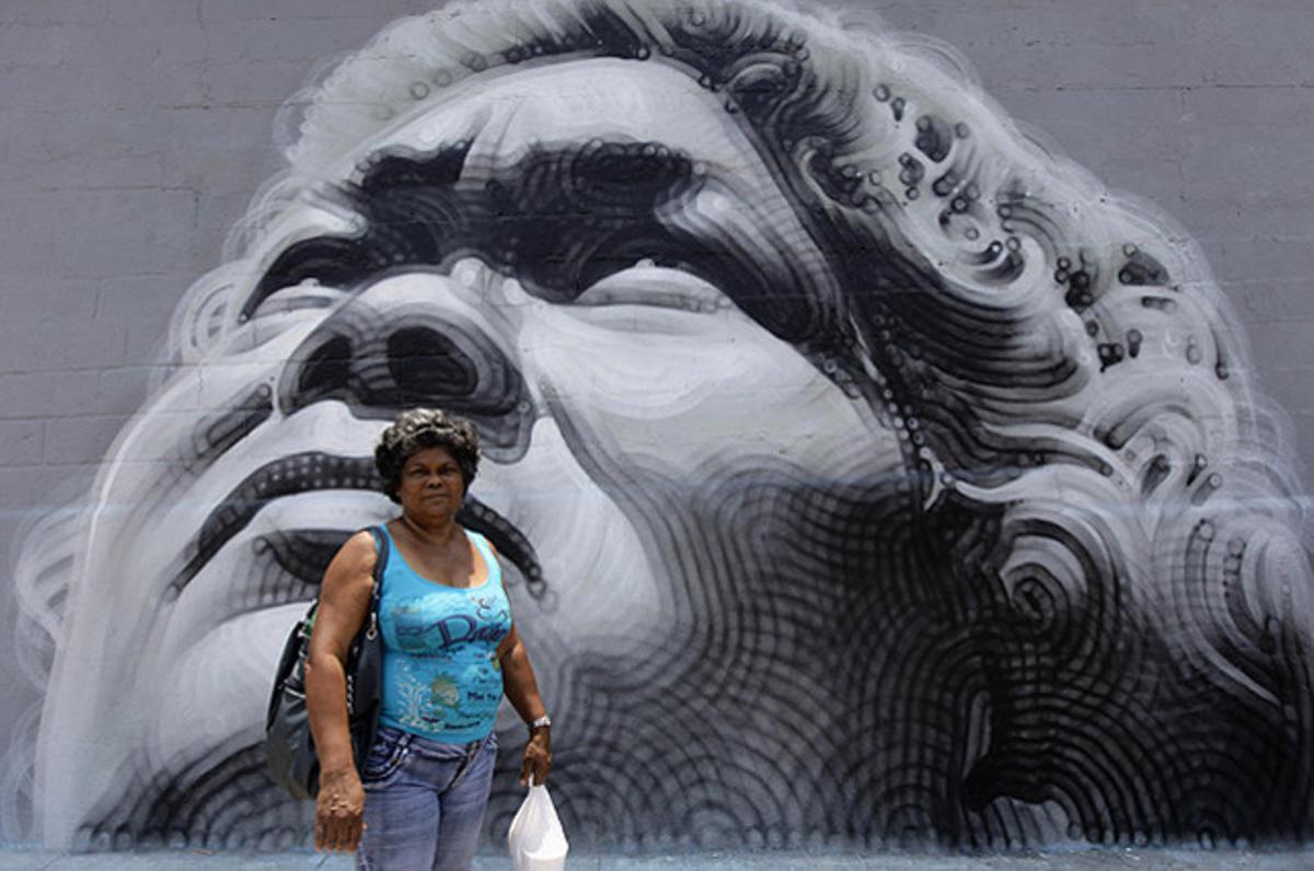 La cuinera cubana Adis Naranjo, davant d’un mural amb la seva cara, pintat per l’artista Miles MacGregor, durant la Biennal d’art contemporani de l’Havana.