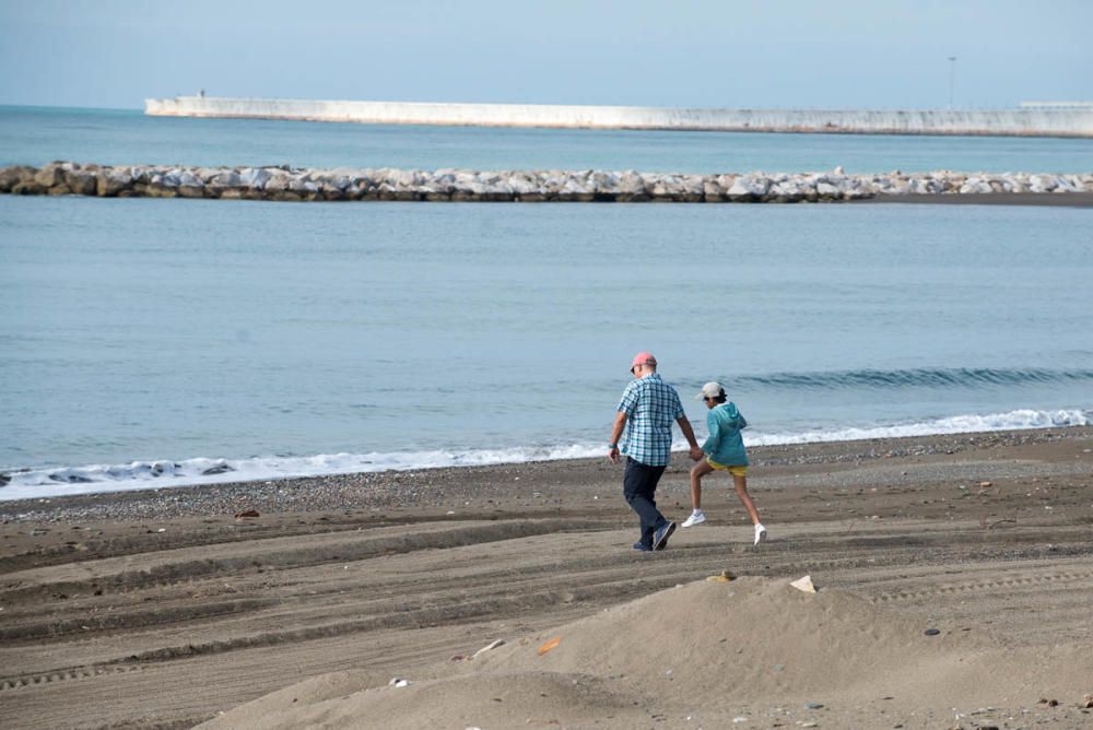 Padres e hijos aprovechan el primer día del desconfinamiento parcial de los niños menores de 14 años para dar un paseo por calles y plazas del Centro de Málaga. En la playa, algunos pequeños aprovechaban para remojarse los pies, bordeando una de las prohibiciones de esta nueva medida.