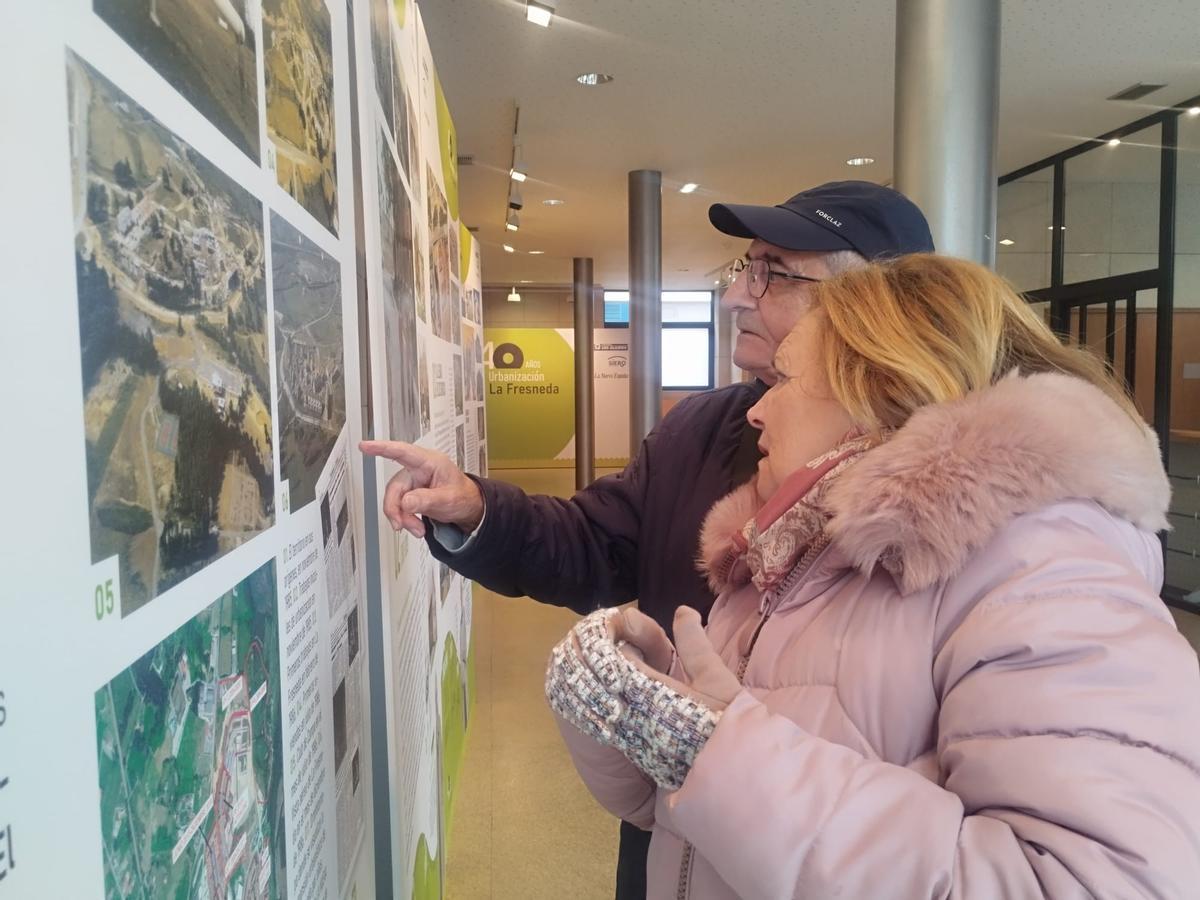 José Luis García y Joaquina Monte, pioneros de la urbanización, buscan su casa en las imágenes de la muestra.