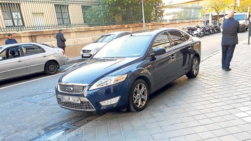 Un coche oficial pasa veinte minutos  sobre  la acera a las puertas del área de Tráfico