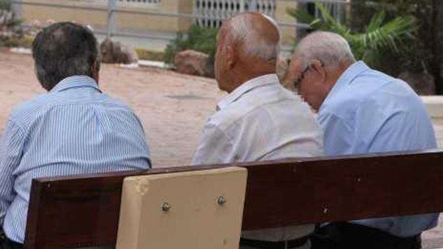 Tres ancianos sentados en un banco.