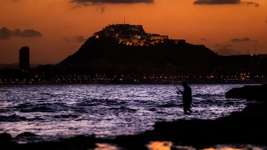 La fotografía de los últimos rayos de sol sobre la bahía de Alicante con el Castillo de Santa Bárbara de fondo.