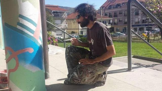El artista "Peri Helio", ayer por la mañana, pintando una de las cinco columnas de los soportales del Concello. // G. Núñez/ F.G.S.