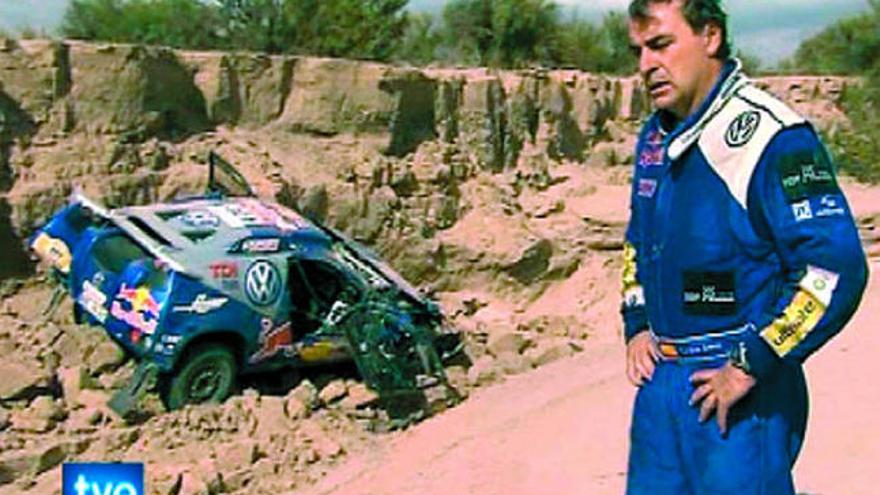 Imagen tomada de televisión en la que aparece Sainz con su coche sobre unas piedras. / efe