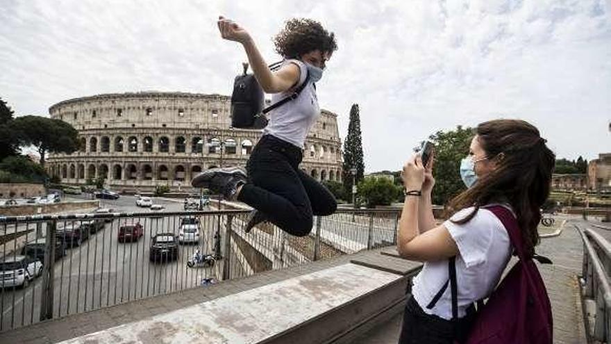 Unas amigas se fotografían ayer ante el Coliseo de Roma.