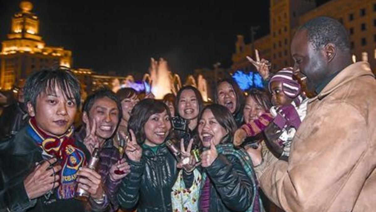 Un grupo de extranjeros celebra la Nochevieja del 2012 en la plaza de Catalunya, donde no hubo fiesta organizada por el ayuntamiento.