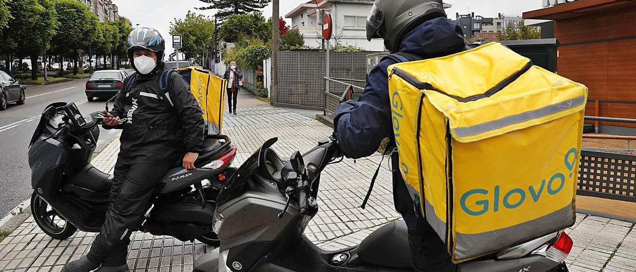 Repartidores de comida a domicilio de Glovo delante de McDonald’s en Vigo.