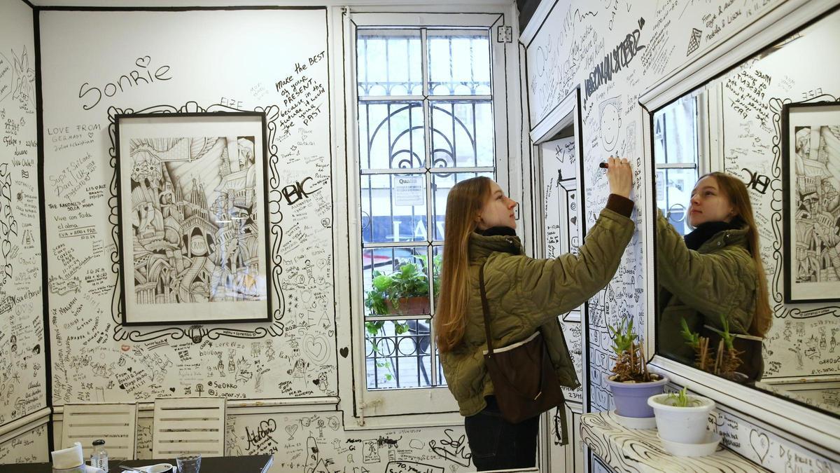 Una clienta dibuja en una de las paredes del café 2D.