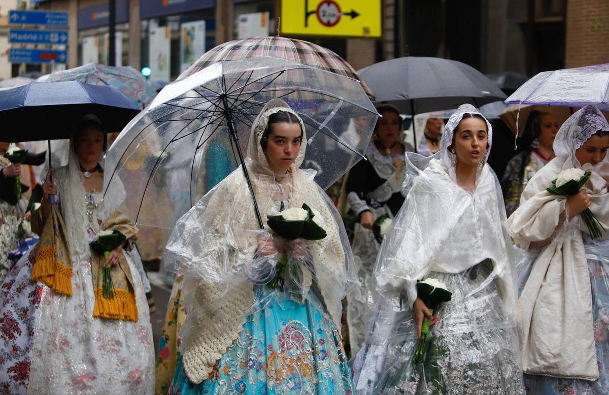 Un grupo de falleras se protege de la lluvia en la Ofrenda del año pasado.