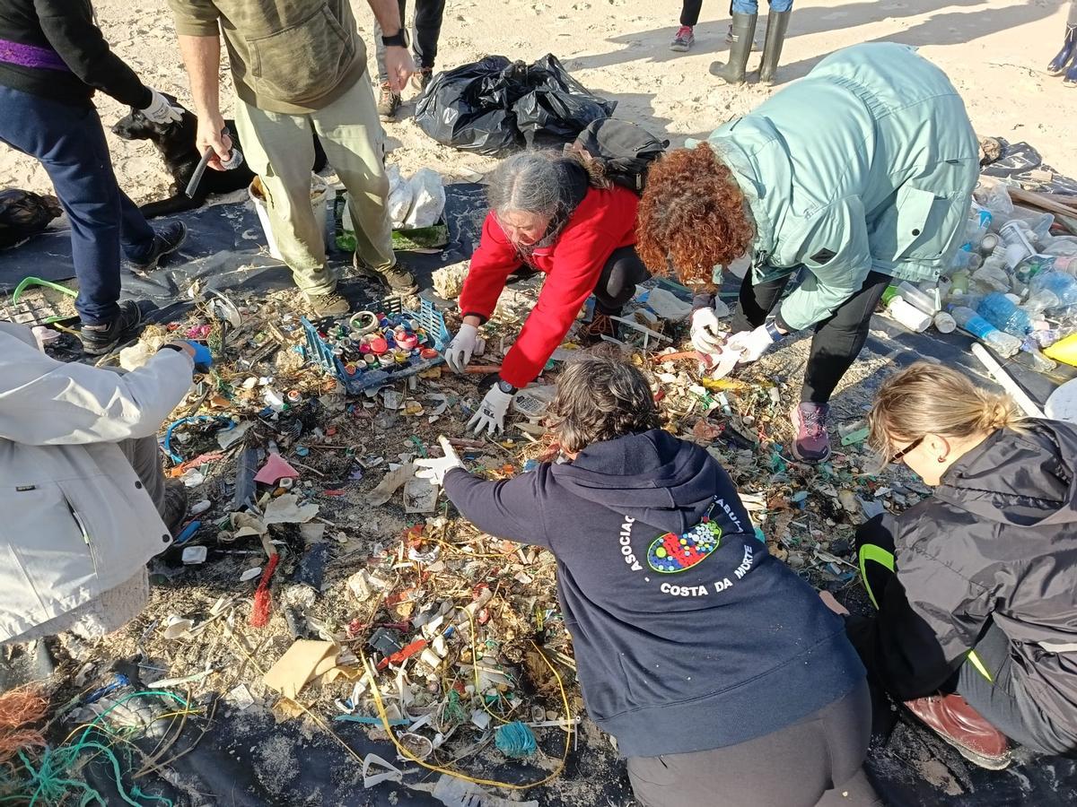 Voluntarios seleccionando o lixo recollido no areal de Traba de Laxe.