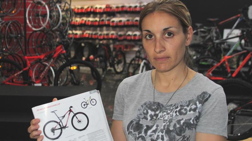 La propietaria del establecimiento asaltado muestra una de las bicicletas robadas.