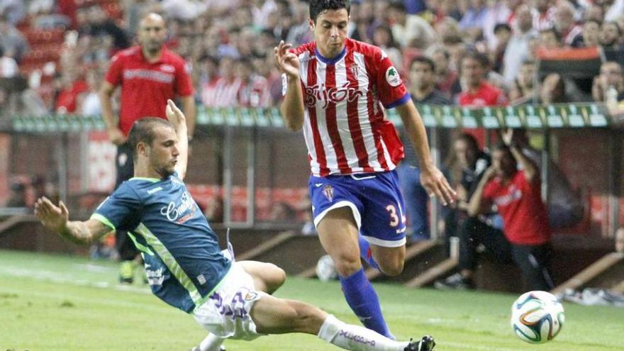 Álvaro Bustos trata de superar una entrada del jugador del Valladolid Carmona.