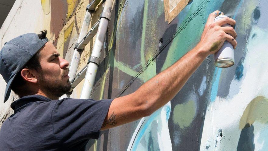 A la izquierda, Ione Domínguez pintando uno de sus murales. Abajo, de izquierda a derecha, su obra