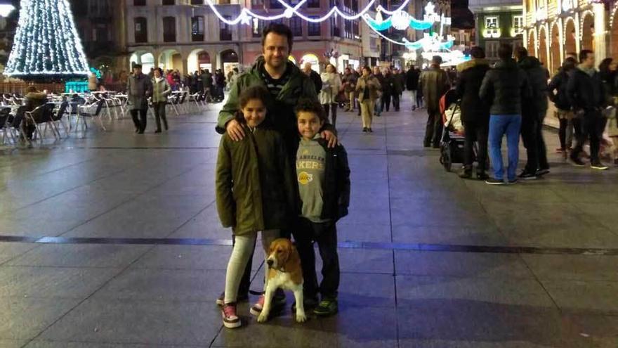 Paula y Daniel García, con su padre, Javier García, y &quot;Luna&quot;, la pasada Navidad, en la plaza de España.