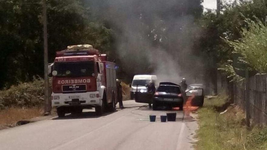 Los bomberos durante las tareas de extinción del fuego en el vehículo. // Cedida